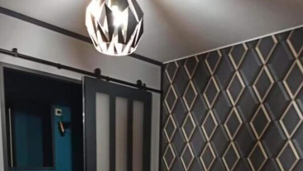 Une chambre à coucher avec un lit, une armoire et une salle de bain visible à travers une porte ouverte.