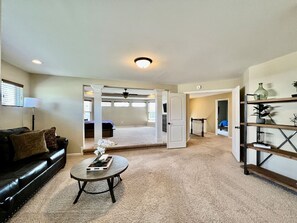A spacious living room with a black leather sofa, a round coffee table, and a bookshelf. - Large Executive Home In Lebanon Golf Community (Lebanon)