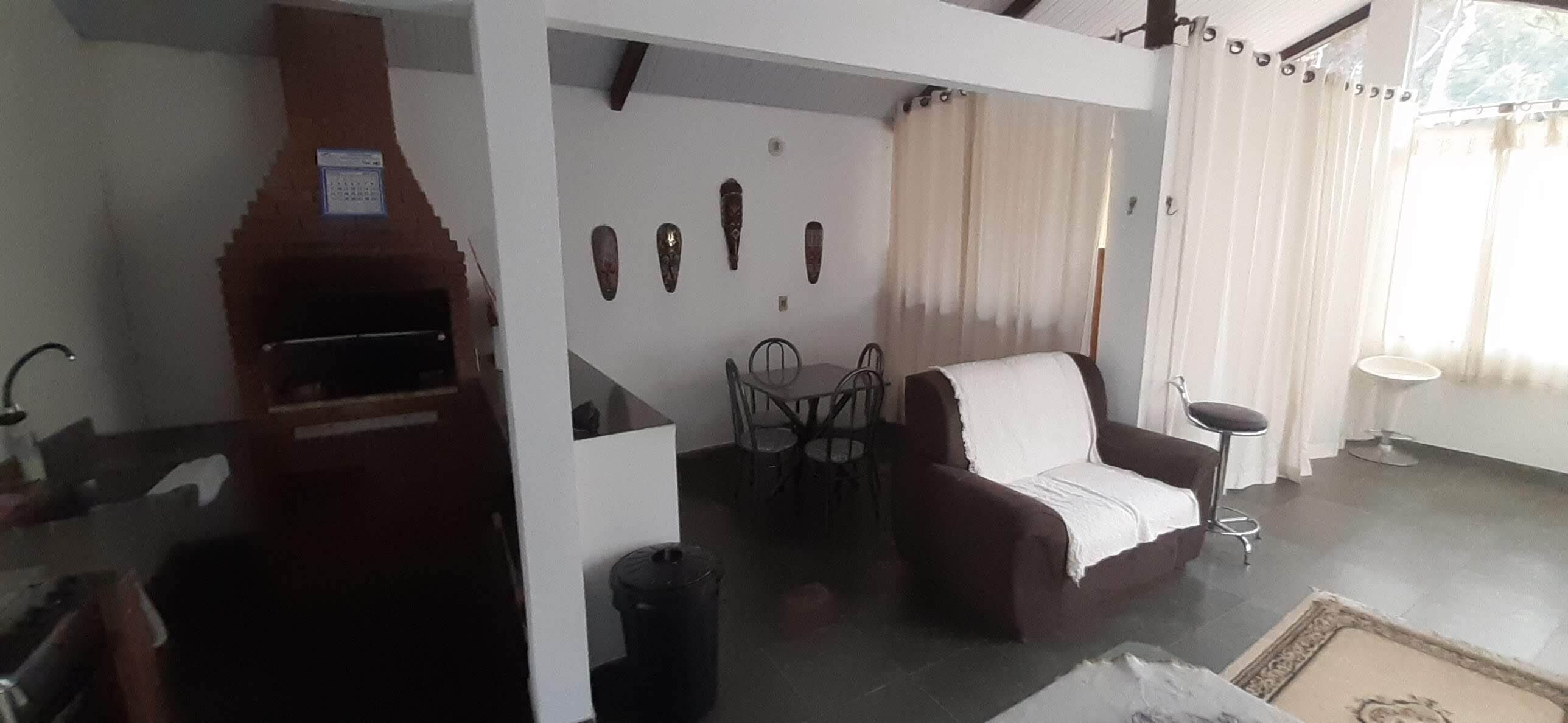 A living room with a sofa, a dining table with chairs, a small bar area, and a fireplace.