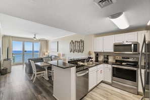 A modern kitchen with white cabinets, stainless steel appliances, and a large island. - Calypso 2-1002 West Tower! Gulffront, Free Beach Service and Walk to Pier Park! (Panama City Beach)