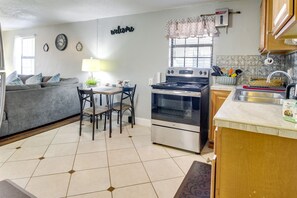 Frigorífico, placa de cocina, utensilios de cocina y mesa de comedor
