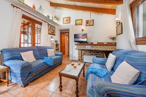 A living room with two sofas, a coffee table, a television, and a fireplace. - Villa Bon Redos by JS Villas (Pollensa)