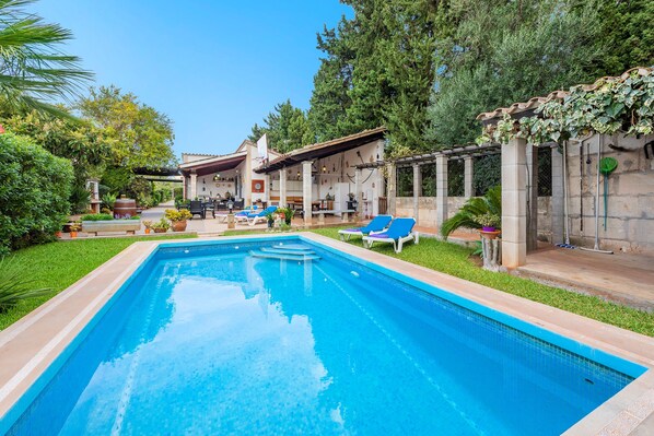 A swimming pool with lounge chairs, a pergola, and a garden with various plants. - Villa Bon Redos by JS Villas (Pollensa)