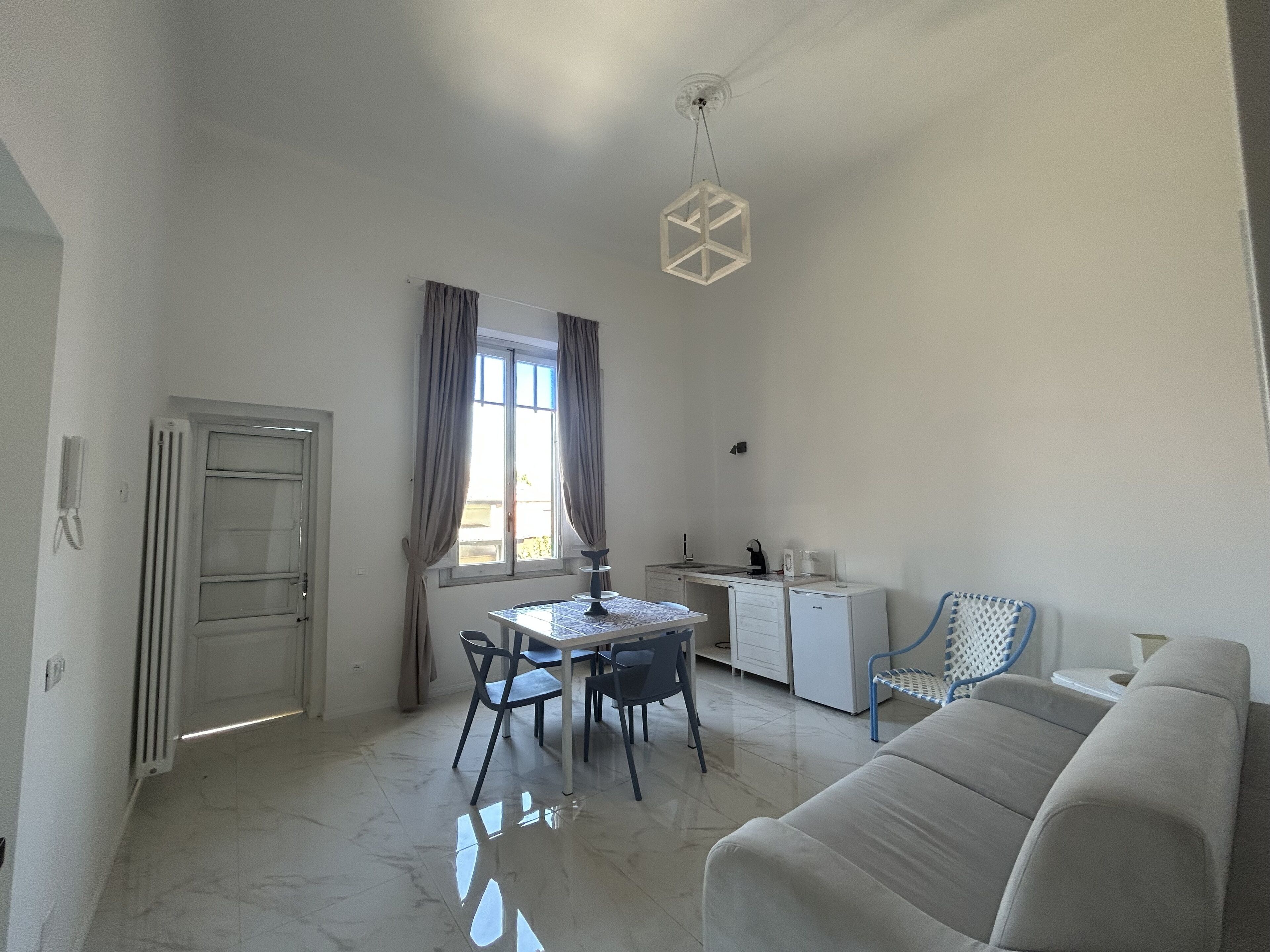 A compact living space with a dining area, kitchenette, and a sofa.