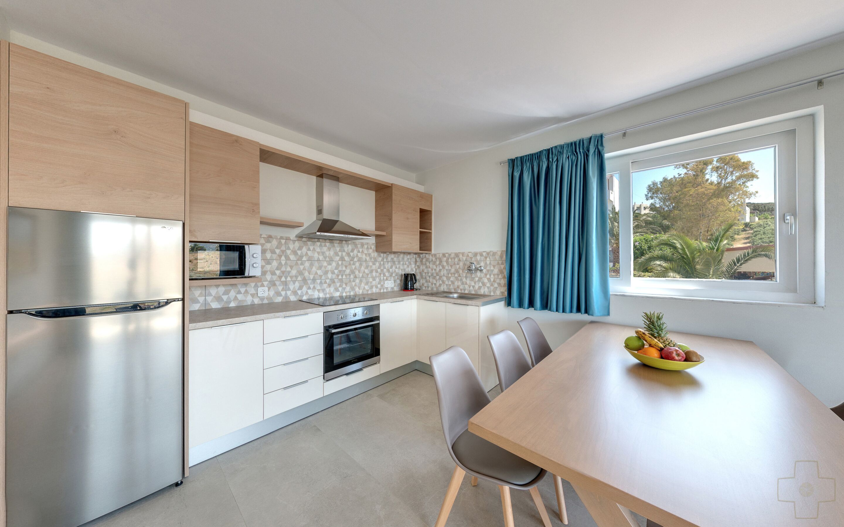 A modern kitchen with a built-in oven, microwave, and stainless steel refrigerator.