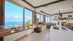 A breakfast buffet with a view of the ocean, wooden beams, and a rustic interior.