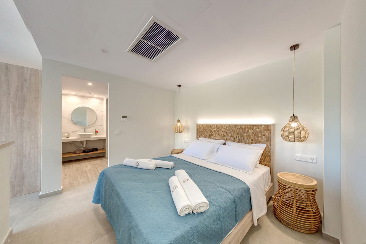 Une chambre à coucher moderne, équipée d’un lit, de lampes de chevet, d’une table de chevet et d’un radiateur fixé au mur.