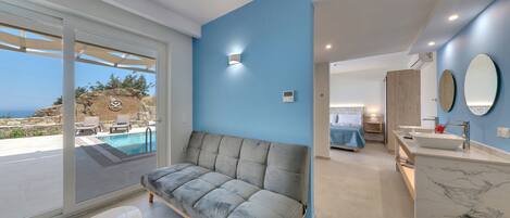 Ein modernes Schlafzimmer mit Bett, Nachttisch und Meerblick.