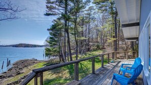 A wooden deck with a railing overlooking a lake, surrounded by trees. - Edgecomb Maine.  Close to Boothbay & Wiscasset.  Very private and relaxing. (Edgecomb)