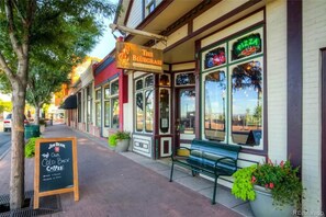 A storefront with a sign for 'The Bluegrass Coffee & Brewing Lounge' and a neon sign for 'Pizza'.