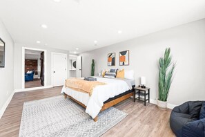 Een moderne slaapkamer met een bed, nachtkastje en een potplante.