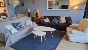 Una sala moderna con una cama, dos sofás, una mesa de centro y un comedor.
