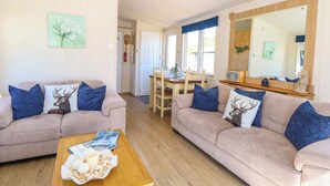 A living room with two sofas, a coffee table, and a dining area with a table and chairs. - 25 Foxburrow Hang (Great Yarmouth)