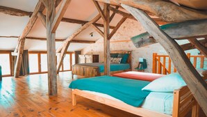 A rustic bedroom with wooden beams, a wooden bed, and a small desk. - Le Moulin de L'Isle - Maison chaleureuse (L'Isle-Bouzon)