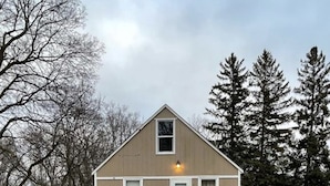 A small, single-story house with a gabled roof, a front porch, and a mailbox.