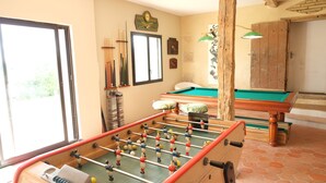 Une pièce équipée d’un baby-foot, d’une table de billard et d’une table de pool.