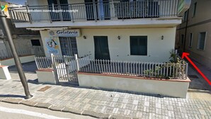 A building with a sign reading "Gelateria" and a fenced area with plants. - B & SunSea (Agropoli)