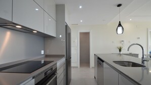 A modern kitchen with stainless steel appliances, a central island with a sink, and recessed lighting. - Ocean Homes 5203 - Two Bedroom Apartment, Sleeps 5 (Punta del moral)