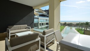 A balcony with a view of a pool and beach, furnished with a sofa and a table. - Ocean Homes 5203 - Two Bedroom Apartment, Sleeps 5 (Punta del moral)
