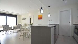 A modern kitchen with a central island, a dining area with chairs, and a large window. - Ocean Homes 5203 - Two Bedroom Apartment, Sleeps 5 (Punta del moral)