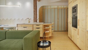 Une cuisine moderne avec des meubles en bois, un four encastré et un mur à rayures.