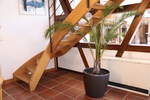A wooden staircase with a potted plant on the landing.