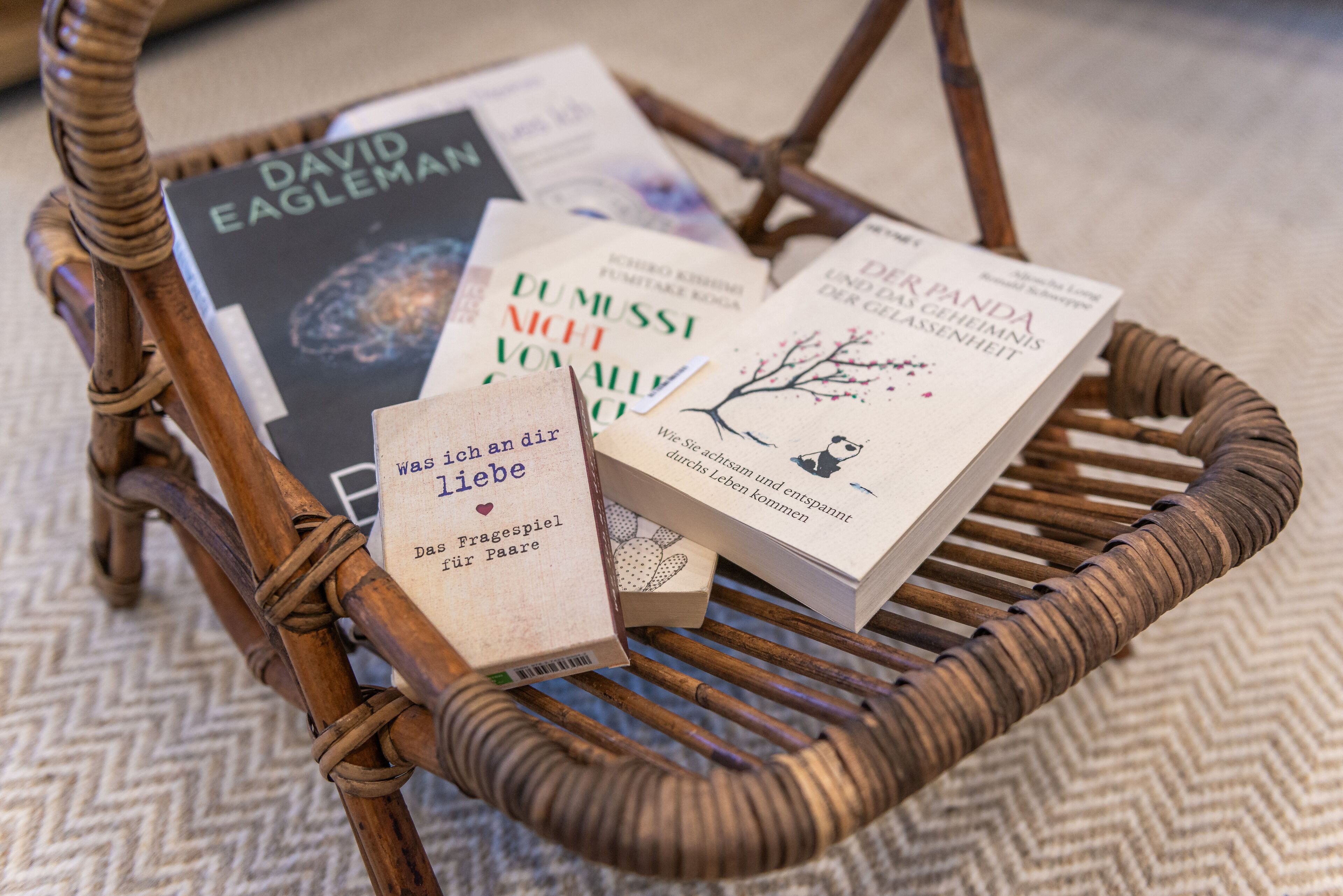 Una cadira de vimetra amb diversos llibres a sobre.