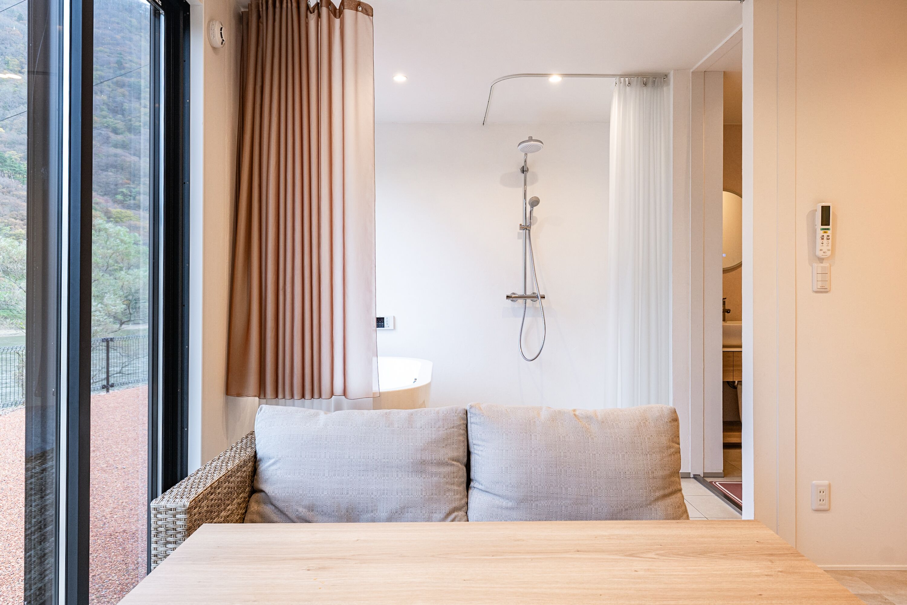 Een moderne badkamer met een douche, wastafel en uitzicht op de omgeving.
