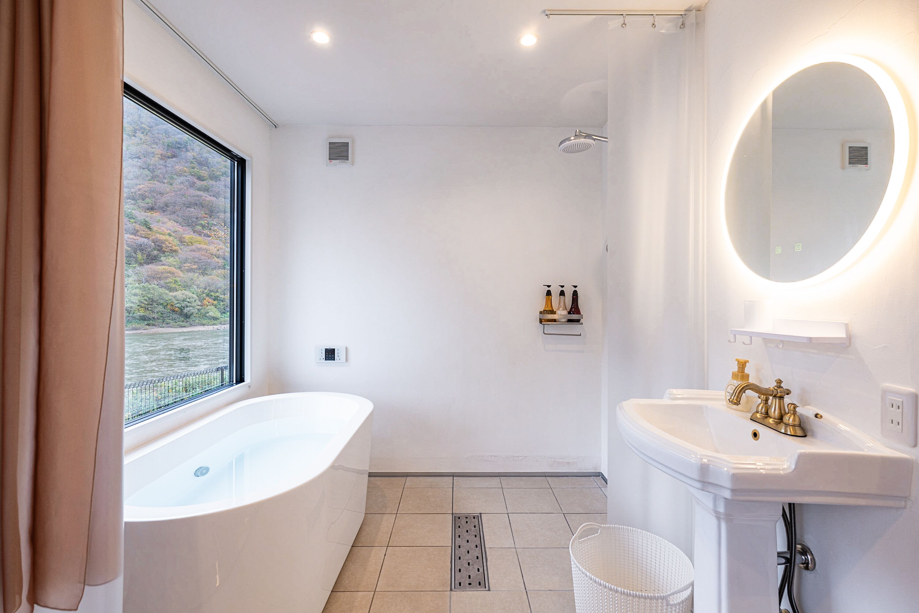 A modern bathroom with a bathtub, a sink, and a shower.