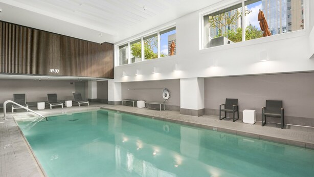 Une piscine intérieure dotée de nombreux chaises longues et d’un design moderne.