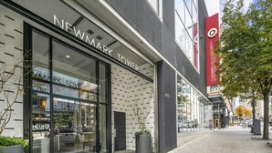 Un bâtiment moderne avec une façade vitrée sur laquelle on peut lire l’inscription « NEWMARK TOWER ».