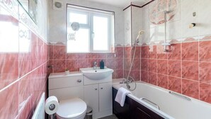 Un baño pequeño con inodoro, lavamanos y bañera.