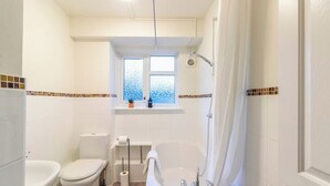 A bathroom with a bathtub, toilet, and window. - Beautiful Sea View 2 bedroom Sleeps 6-Free Parking (Bournemouth)