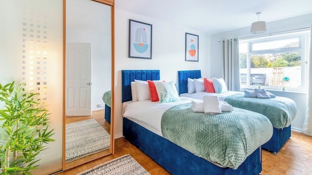 A bedroom with two beds, a sliding door, and a large window. - Beautiful Sea View 2 bedroom Sleeps 6-Free Parking (Bournemouth)