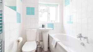 A bathroom with a toilet, sink, and bathtub.