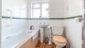 A bathroom with a bathtub, sink, toilet, and a window. - Large Sea View 2 bedroom Sleeps 6 - Free Parking (Bournemouth)
