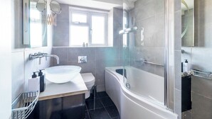 Une salle de bain moderne avec un lavabo, des toilettes et une baignoire, le tout de couleur blanche.