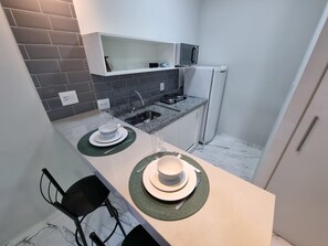 Refrigerador, microondas, utensilios de cocina, mesa de comedor