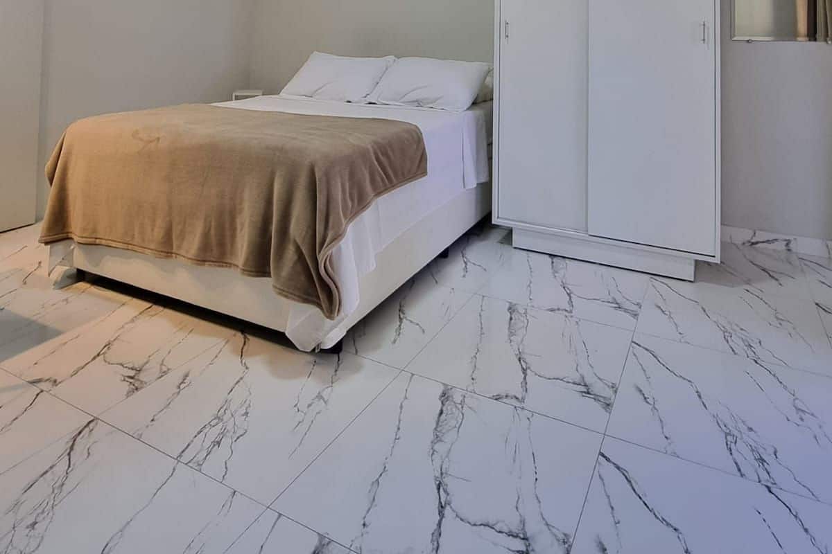 A bedroom with a bed, a wardrobe, and a mirror.
