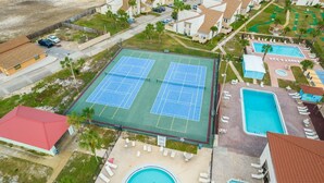 Asuinalue, jossa on tenniskenttä, kaksi uima-allasta ja punakattoinen rakennus.