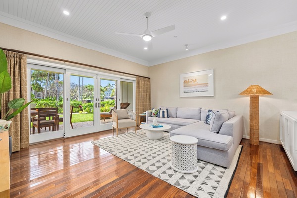 Bright living space with cozy seating, natural light, and serene garden views.