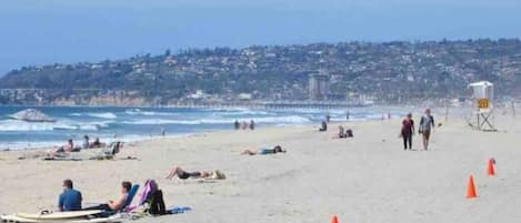 Una playa cerca, sillas reclinables de playa, toallas de playa