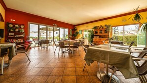 A spacious indoor area with a dining table, chairs, and a bookshelf. - Lovely 2 Bedroom Apt, Oasis Parque, Alvor (Portimão)