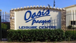 A sign for Oasis Parque Leisure Centre with a clear view of the entrance gate and surrounding greenery. - Lovely 2 Bedroom Apt, Oasis Parque, Alvor (Portimão)
