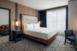 A hotel room with a large bed, a bedside table, a chair, a desk, a mirror, and a window with curtains. - The Hoffmann Hotel Basalt Aspen, Tapestry Collection By Hilton (Basalt)
