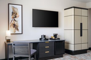 A hotel room with a desk, chair, a flat-screen TV, a coffee machine, and a wardrobe. - The Hoffmann Hotel Basalt Aspen, Tapestry Collection By Hilton (Basalt)