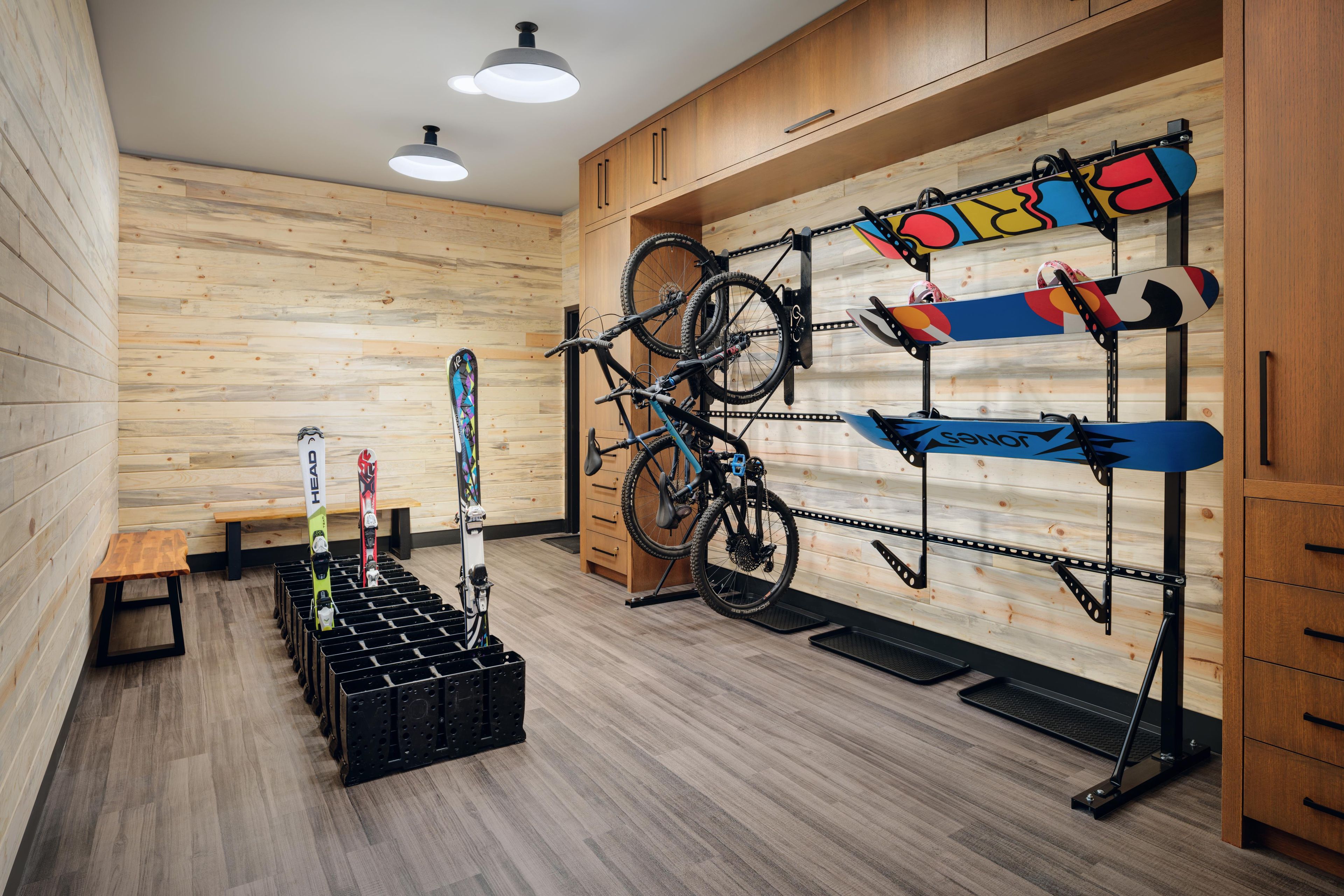 Une pièce aux murs en bois, avec un porte-vélos et un banc.