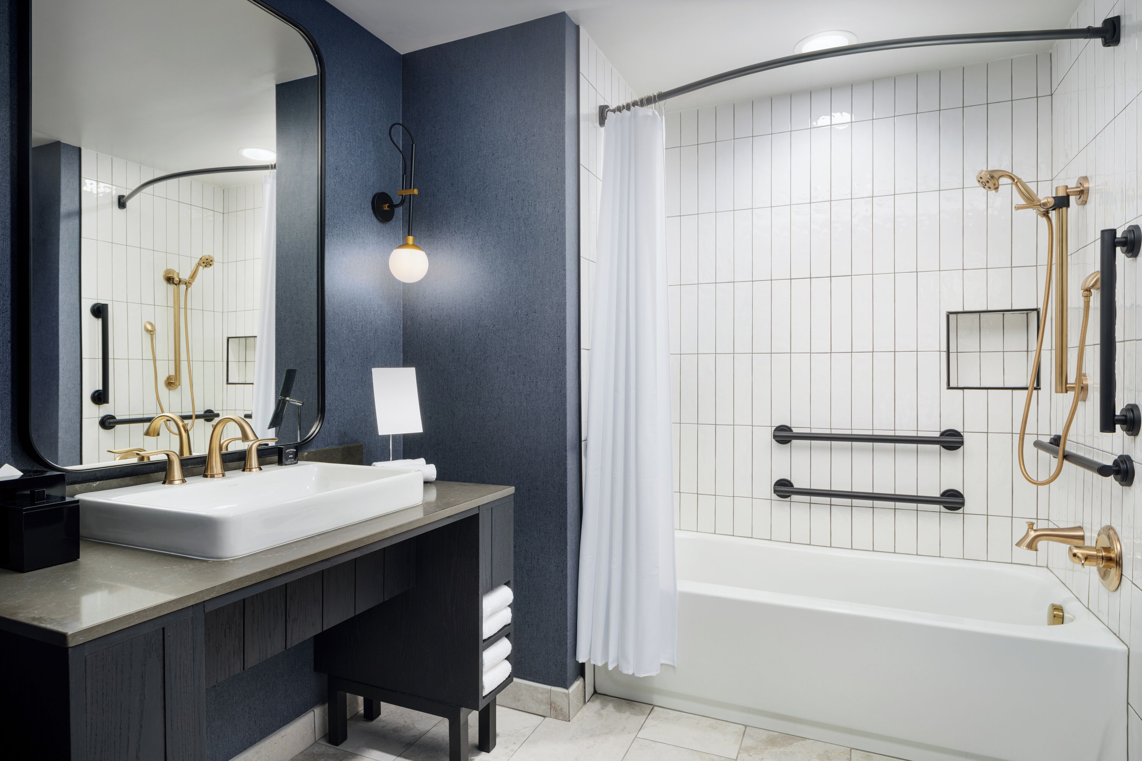 Un baño moderno con un lavamanos grande, espejo y zona de ducha.