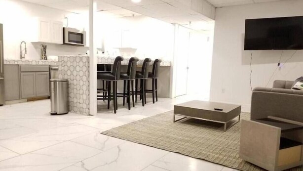 Un salon moderne avec un canapé, une table basse et un téléviseur fixé au mur.