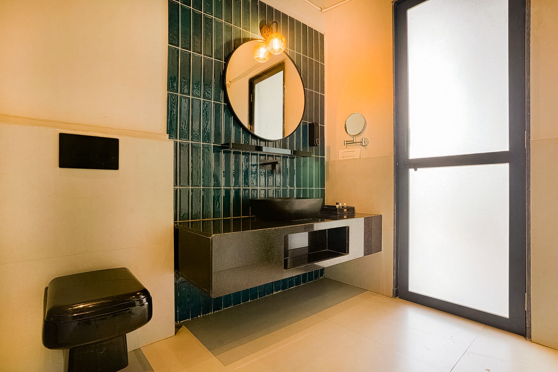 A modern bathroom with a black sink, a mirror, and a toilet.